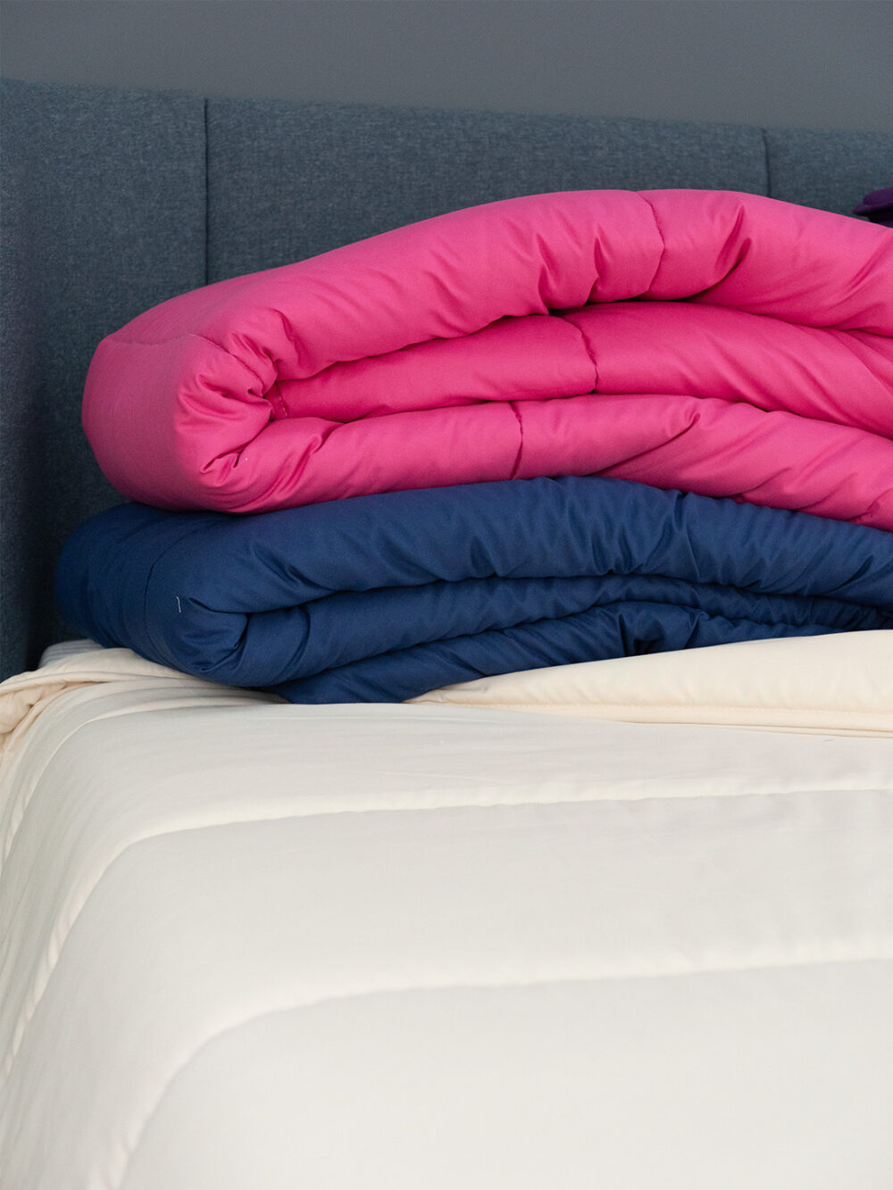Edredões de várias cores para camas de solteiro e casal.